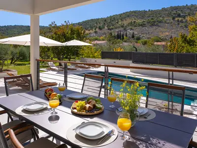 Überdachter Essbereich im Freien für 10 Personen, ideal für Mahlzeiten an der frischen Luft und Vormittage am Pool.