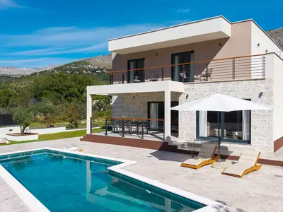 Modernes zweistöckiges Design mit einer stilvollen Steinfassade und einem erfrischenden, 30 m2 großen privaten Pool.