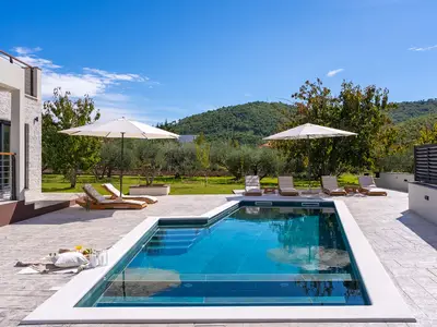 Genießen Sie die Sonne auf der Terrasse mit 10 bequemen Liegen und einem atemberaubenden Blick auf die Berge.