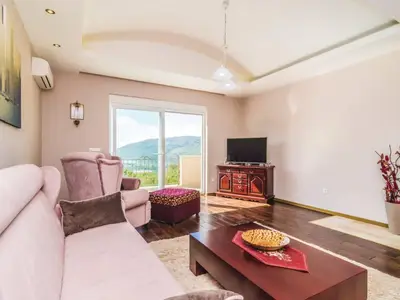 Wohnzimmer mit TV-Ecke und Ausgang zum Balkon