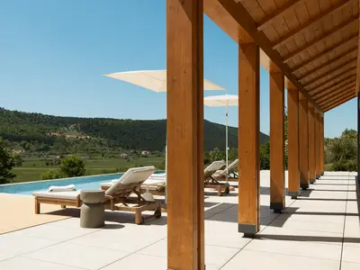 Eine überdachte Terrasse mit Sommerküche bietet den perfekten Rahmen für Mahlzeiten im Freien und geselliges Beisammensein.