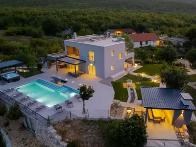 Abendaufnahme der beleuchteten Villa, 66m2 Pool, privater Garten und ruhige Hügel.