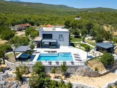 Blick auf die Villa, Steinmauern und gepflegte Anlagen in ruhiger, ländlicher Umgebung.