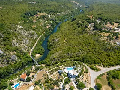 Luftaufnahme der Immobilie und ihre Nähe zum Fluss.