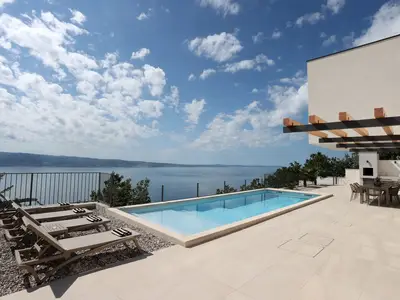 Entspannen Sie am 33m2 Pool auf dem Sonnendeck und genießen Sie den Panoramablick auf das Meer.