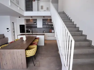 Der 60m2 Wohnbereich bietet einen stilvollen Esstisch mit direktem Zugang zum Poolbereich.