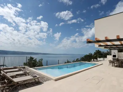 Entspannen Sie am 33m2 Pool auf dem Sonnendeck und genießen Sie den Panoramablick auf das Meer.