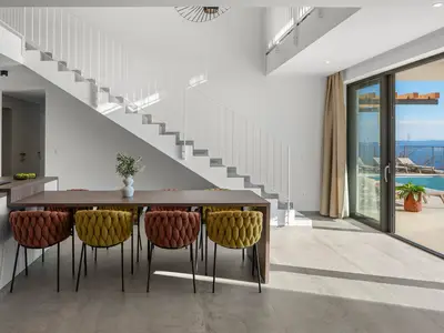 Der 60m2 Wohnbereich bietet einen stilvollen Esstisch mit direktem Zugang zum Poolbereich.