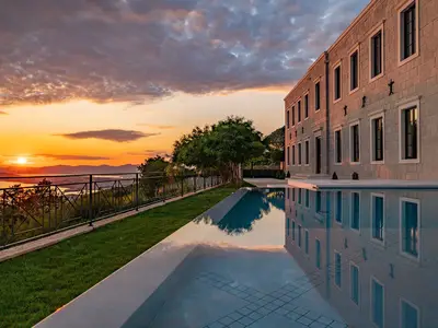 Erleben Sie Komfort und spektakulären Meerblick am beheizten Infinity-Pool bei Sonnenuntergang.