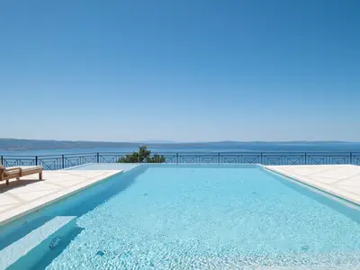 Der 10x5m beheizte Pool mit Hydromassage und Flachwasserbereich schafft eine elegante Atmosphäre.