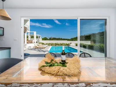 Eine Sommerküche mit TV, Grill, Esstisch für 8 Personen und Toilette
