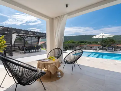 Der Sitzbereich im Freien befindet sich neben dem Pool und bietet einen atemberaubenden Blick auf die Berge.