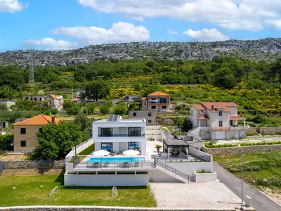Blick auf die Villa Mirage mit Kinderspielplatz und natürlicher Umgebung.
