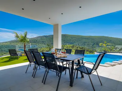 Eine überdachte Terrasse mit einem gemütlichen Essbereich im Freien