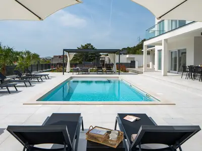ein großer, 47 m2 (10,5 m x 4,5 m) großer, glitzernder privater Pool mit zehn Liegestühlen