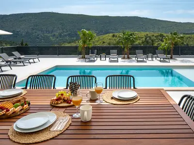 A covered outdoor dining table with seating for ten people
