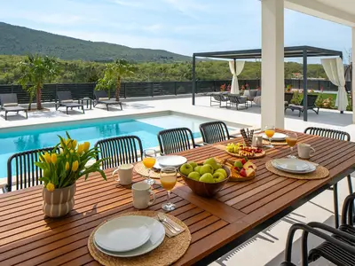A covered outdoor dining table with seating for ten people
