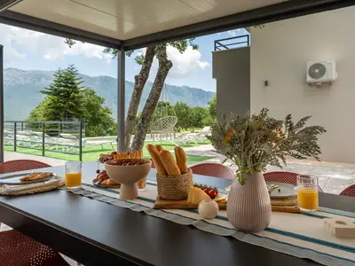 Daneben befindet sich ein überdachter Essbereich im Freien mit dem traditionellen Grill