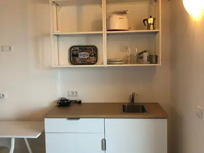kleiner Schrank mit Kühlschrank, Kaffeemaschine, Mokkakanne, Toaster und Spüle